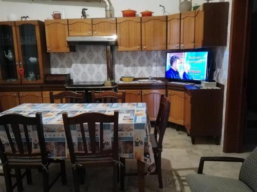 una cucina con tavolo e TV di Villino Schiavone a Racale