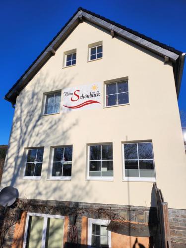 a white building with a sign on it at Haus Schönblick in Simmerath