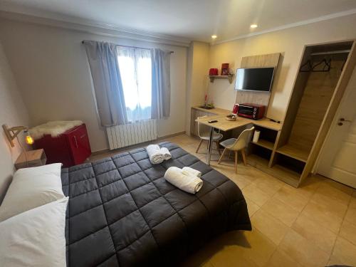 a bedroom with a bed and a desk with a computer at Hosteria Yamile in El Calafate