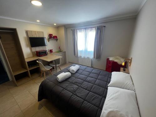 a bedroom with a bed and a desk with a computer at Hosteria Yamile in El Calafate