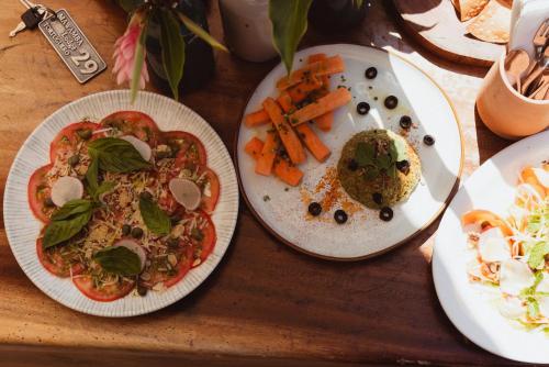 a table with two plates of food and carrots at Mawamba Lodge in Tortuguero