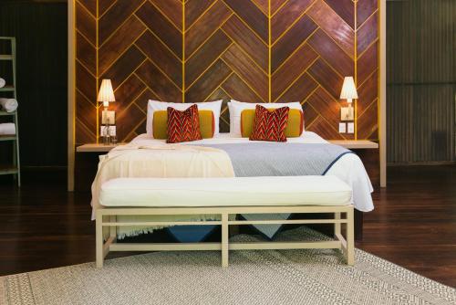 a bedroom with a bed with a wooden wall at Mawamba Lodge in Tortuguero