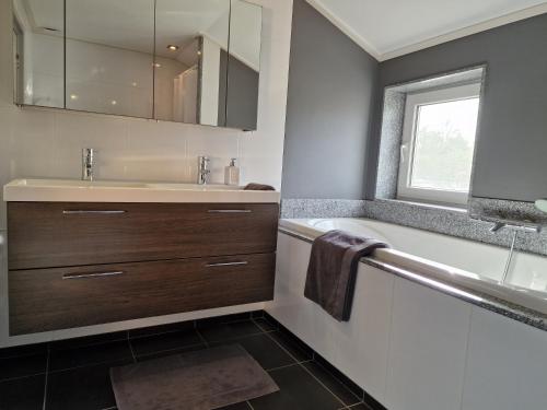 een badkamer met een wastafel en een bad bij Our House in Breskens