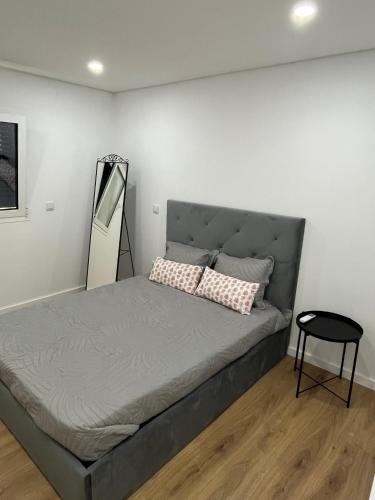 a bedroom with a bed with a mirror on the wall at Casa dos Doces in Póvoa de Lanhoso