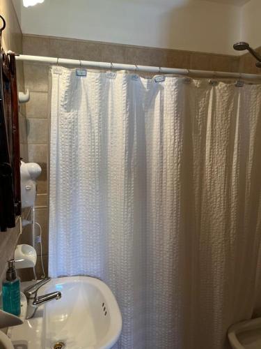 a bathroom with a shower curtain and a sink at Loid Patagonia in Puerto Madryn