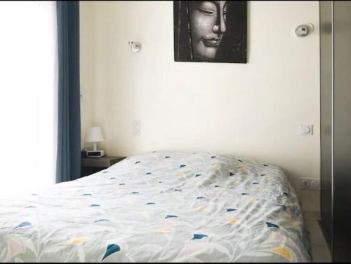 1 dormitorio con 1 cama con una foto de una mujer en T1 proximité de Montpellier., en Juvignac