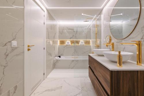 een badkamer met 2 wastafels, een bad en een spiegel bij Grand Horizon Luxury Boutique Apartments in Puerto Rico de Gran Canaria