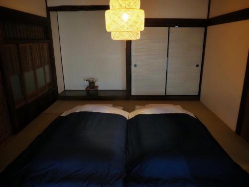 a bedroom with two beds and a chandelier at Kominka Washinkan - Vacation STAY 13791 in Yaita