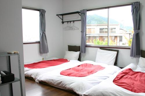 two beds in a room with two windows at RETRO retro - Vacation STAY 03865v in Azagawa
