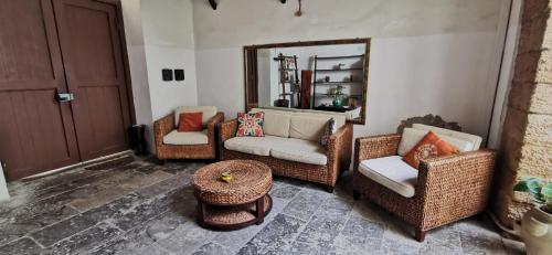 Una sala de estar con sillas de mimbre y un espejo. en Casa Bellini, en Palermo