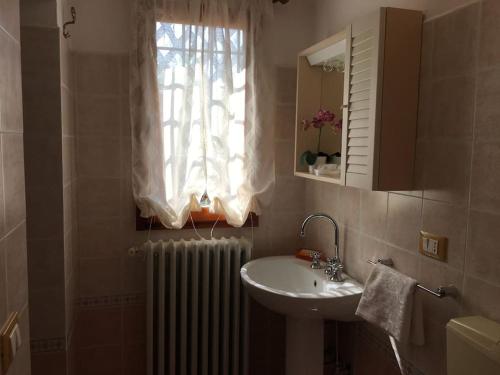 a bathroom with a sink and a window and a radiator at Podere La Cerraia in Serravalle Pistoiese