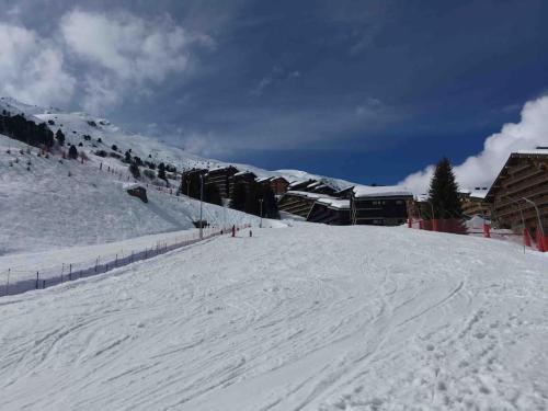 a snow covered ski slope with a ski lodge at Studio skis au pieds Meribel-Mottaret in Les Allues