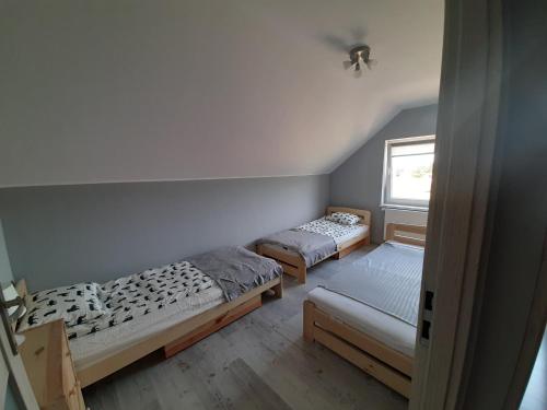 een kamer met 3 bedden en een raam bij Wakacje nad morzem w Rusinowie in Rusinowo