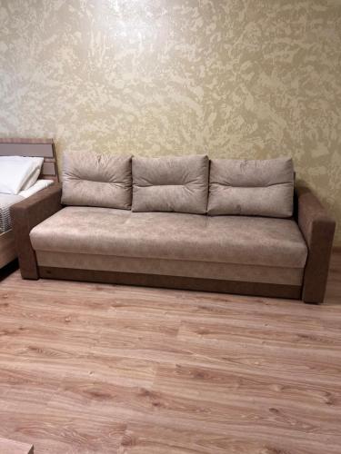 Kärberi Apartments في تالين: أريكة في غرفة معيشة مع أرضية خشبية