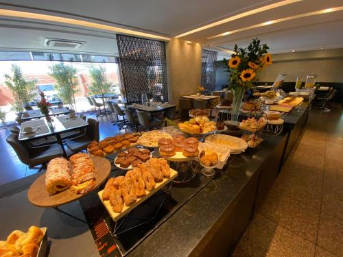 una línea de buffet con muchos tipos diferentes de comida en Aruá Hotel en Presidente Prudente