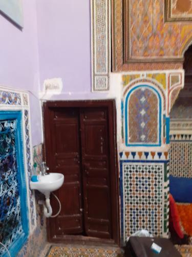 La salle de bains est pourvue d'un lavabo, d'une porte et de carrelage. dans l'établissement Maison authentique centre médina, à Marrakech