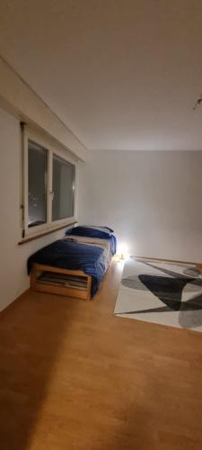 1 dormitorio con 2 camas y ventana en EMANUEL, en Nidau