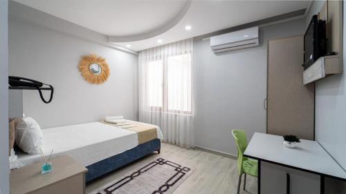 a bedroom with a bed and a table and a desk at KUMBAĞ ŞEHRİ SARAY APART OTEL in Tekirdag