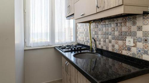 a kitchen with a sink and a stove at KUMBAĞ ŞEHRİ SARAY APART OTEL in Tekirdag