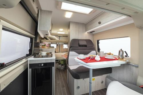 una pequeña cocina y una mesa en una caravana en ODY Van, en Montzen