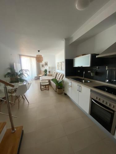 a kitchen and living room with a stove top oven at Villa Bruno con vistas al mar, primera línea de playa in Cotillo