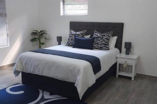- une chambre dotée d'un grand lit avec des oreillers bleus et blancs dans l'établissement Overnight stay. Self-catering., à Klerksdorp
