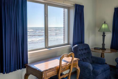 a living room with a table and a chair and a window at Lighthouse Inn - Two Rivers in Two Rivers