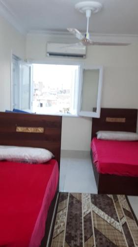 a small room with two beds and a window at وسط البلد عابدين in Cairo
