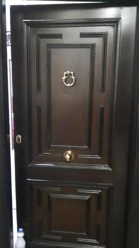 a black door with a gold knocker on it at وسط البلد عابدين in Cairo
