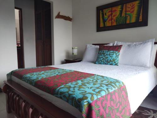 a bedroom with a bed with a colorful blanket on it at Etnias Hotel tematico in Quibdó