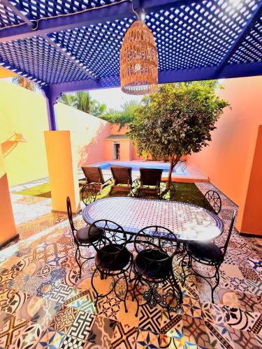 d'une terrasse avec une table et des chaises sur un sol en mosaïque. dans l'établissement Villa Kalthoum, à Marrakech