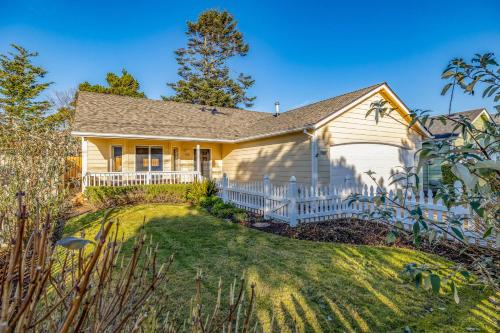 a house with a white fence in the yard at Seas The Day in Seaside