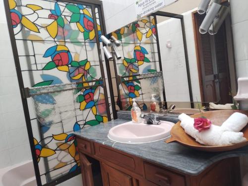 a bathroom with a sink and a stained glass mirror at Etnias Hotel tematico in Quibdó