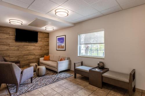 a waiting room with a couch and a tv at Candlewood Suites - Bluffton-Hilton Head by IHG in Bluffton