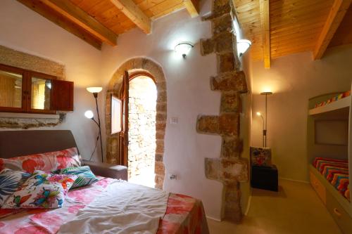 a bedroom with a bed in a room with a stone wall at Affascinante Grande Liama Antica in Salve