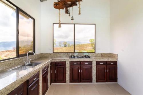 a kitchen with a sink and two windows at Rancho Bellavista, Unique views, Pool and WiFI! in Turrialba
