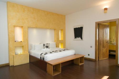 a bedroom with a large bed and a wooden bench at Superior Room Space Available in Accra