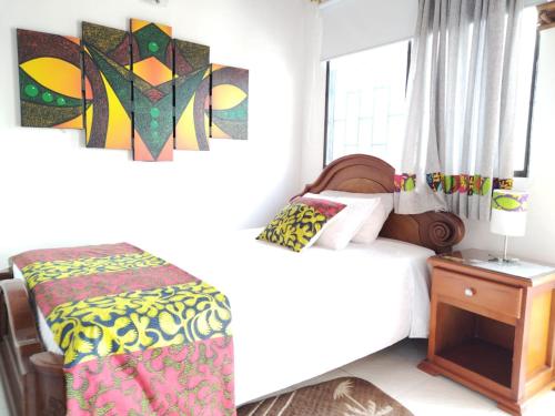 a bedroom with a bed and a table and a window at Etnias Hotel tematico in Quibdó