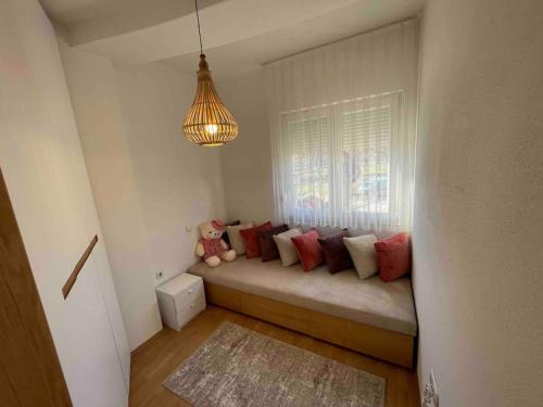 a room with a couch with pillows and a window at Sara’s Stars Apartment in Gjakova in Gjakove