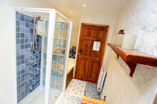 une salle de bain avec une douche avec une porte vitrée dans l'établissement SAUNTON GRANGE 7 Bedrooms, à Braunton