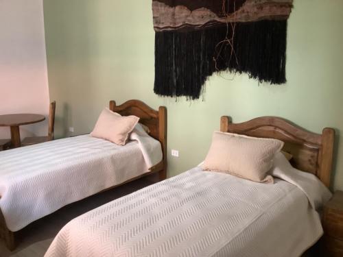 two beds sitting next to each other in a room at Casa San Martin Suites in Cochabamba