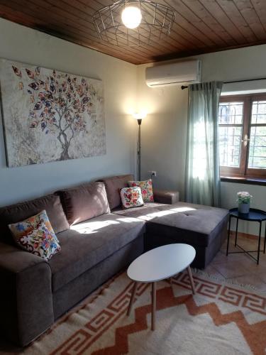 a living room with a couch and a table at Endless View Country House in Makrinítsa