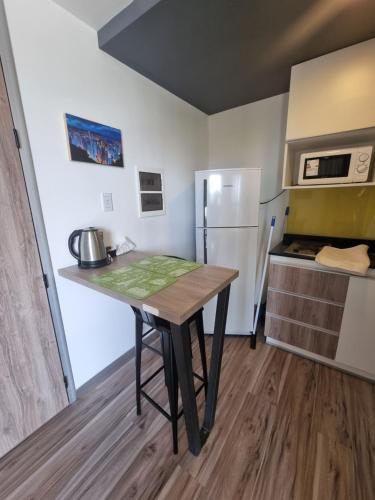 a small kitchen with a table and a refrigerator at BEM Apartamento in Salta