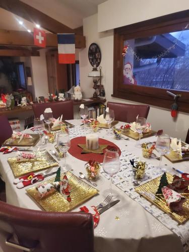a long table with a white table cloth with food on it at Maison Le Lézard chez Amalia et Fred in Thonon-les-Bains