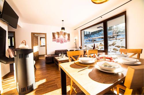 a dining room and living room with a table and chairs at Villa pod hviezdami Jasná in Demanovska Dolina