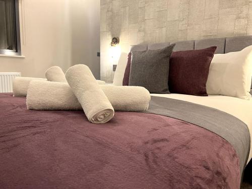 uma cama grande com almofadas em cima em Brand New SILVER FORGE - Charming Two Bedroom Apartment - City Centre - Lux Apartment em Birmingham