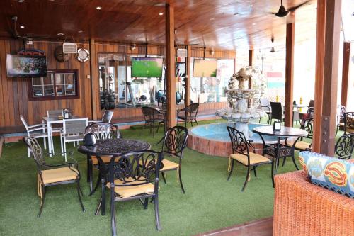 アクラにあるGolden Crystal Experience Hotelのテーブルと椅子、噴水のあるレストラン