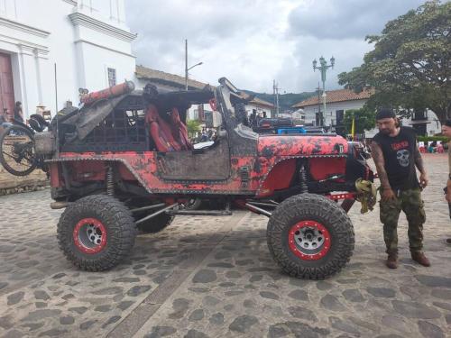 a man is standing next to a red jeep at CASA DOÑA BLANCA in Guaduas