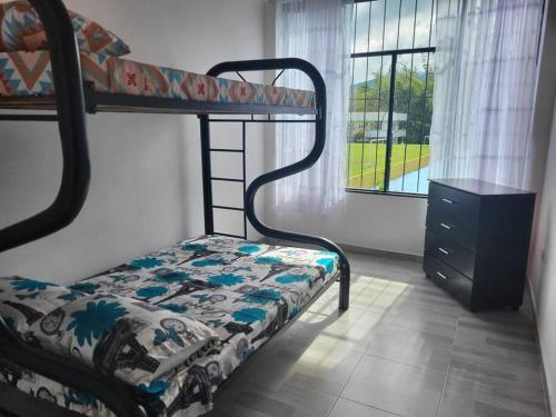 a bedroom with a bunk bed and a dresser and a window at CASA DOÑA BLANCA in Guaduas