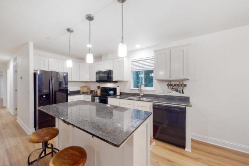 a kitchen with white cabinets and a black refrigerator at Goat Hill in Sebastopol